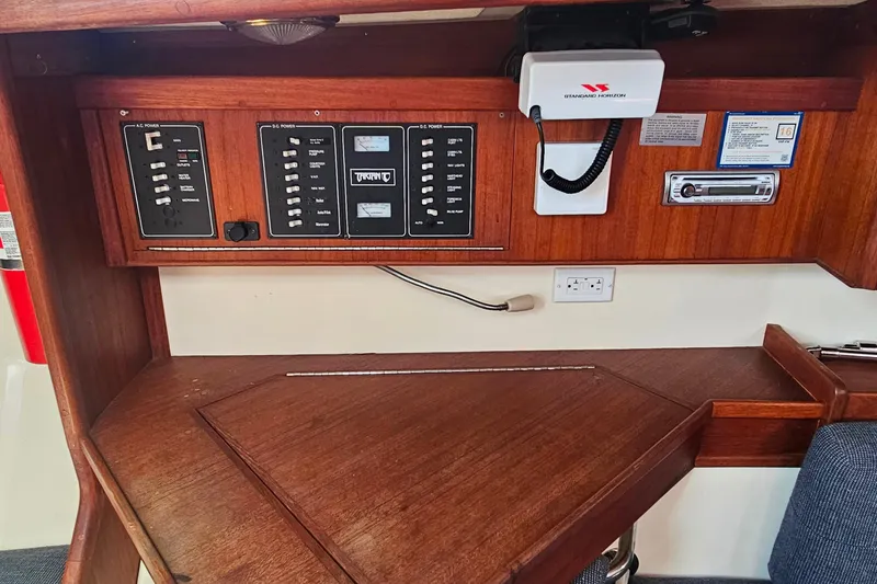 Slide: The Image of Control panel of a 1994 Tartan 3100 yacht with wooden finish and communication equipment. - 16