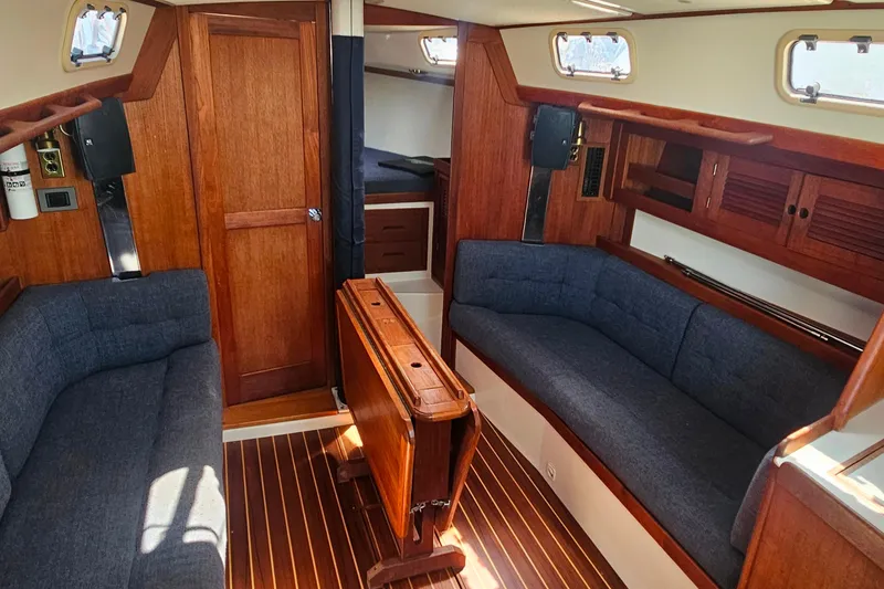Slide: The Image of Interior of a 1994 Tartan 3100 sailboat with wooden finishes and blue seating. - 18