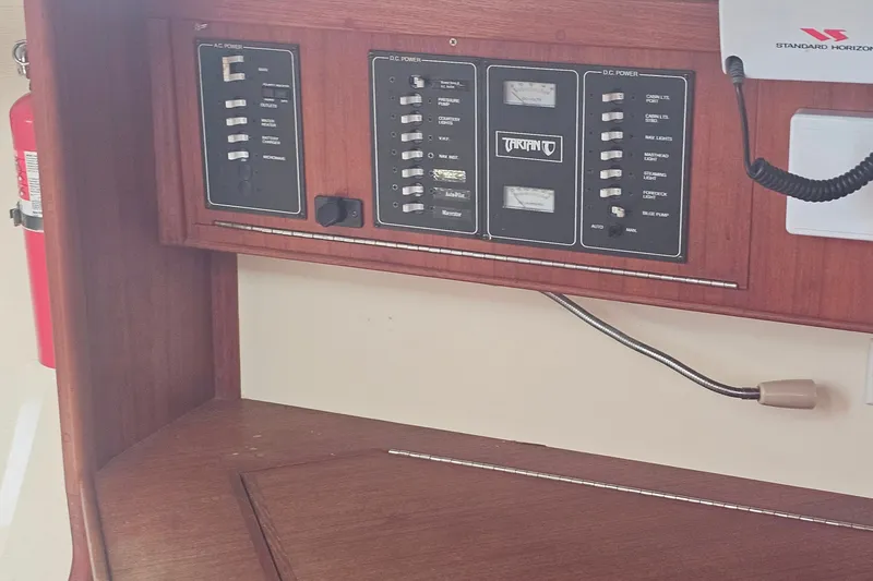 Slide: The Image of Control panel of a 1994 Tartan 3100 boat with AC and DC power switches. - 12