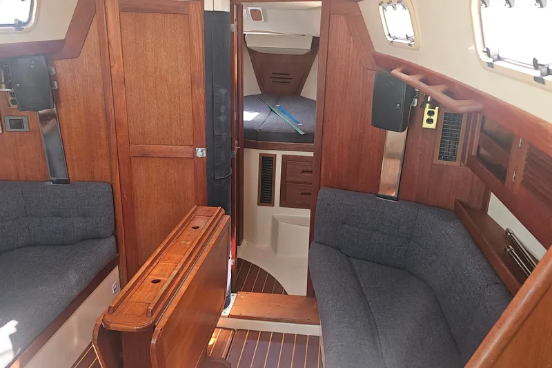 Slide: The Image of Interior of a 1994 Tartan 3100 sailboat with wooden finishes and cozy seating. - 9