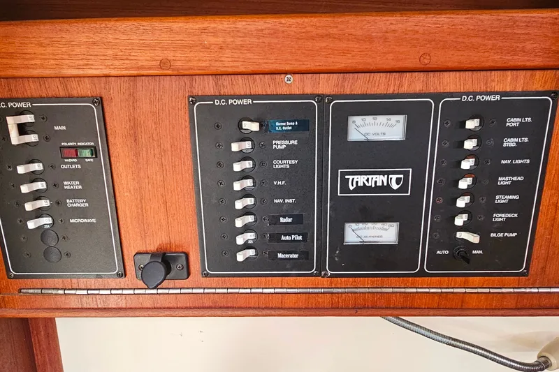 Slide: The Image of Control panel of a 1994 Tartan 3100 boat, featuring various power switches and gauges. - 15