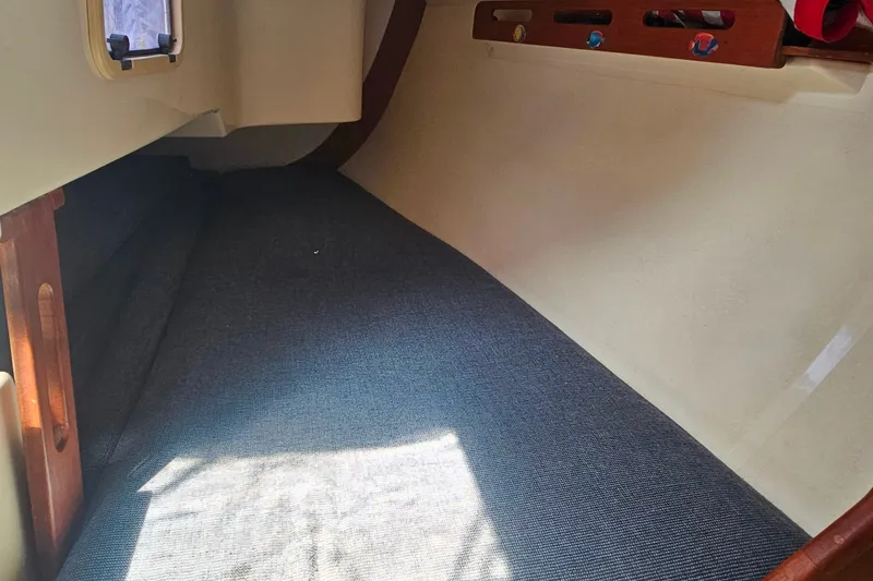Slide: The Image of Interior cabin of a 1994 Tartan 3100 sailboat with blue carpet and wooden accents. - 19
