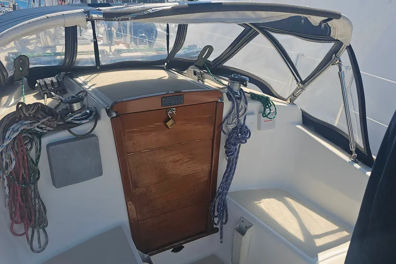Slide: The Image of Cockpit of a 1994 Tartan 3100 sailboat with ropes and wooden hatch. - 3