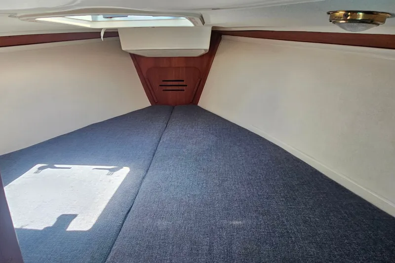 Slide: The Image of Interior cabin of 1994 Tartan 3100 sailboat with carpeted flooring and wooden accents. - 17