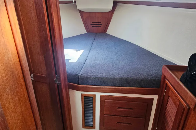 Slide: The Image of Cozy cabin interior of a 1994 Tartan 3100 sailboat with wooden furnishings. - 14
