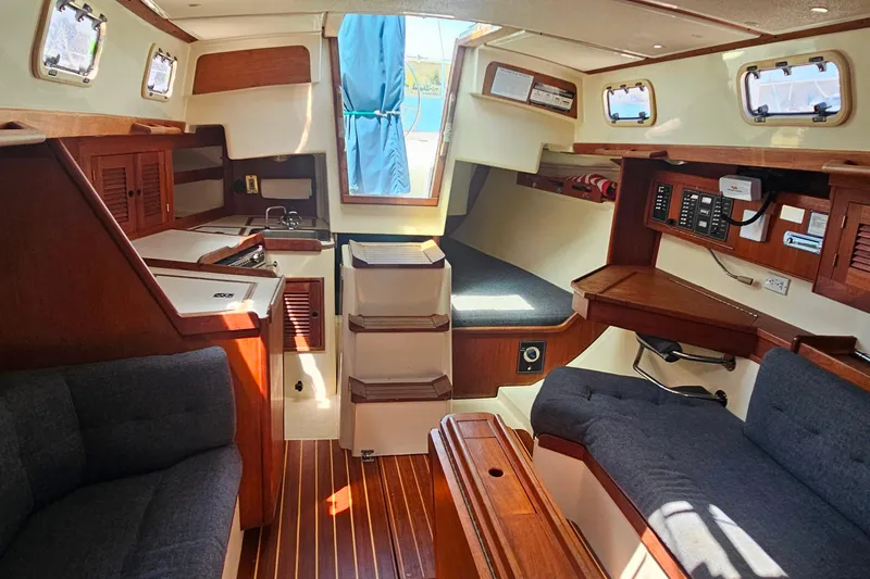 Slide: The Image of Interior of a 1994 Tartan 3100 sailboat with wood finishes and cozy seating. - 20