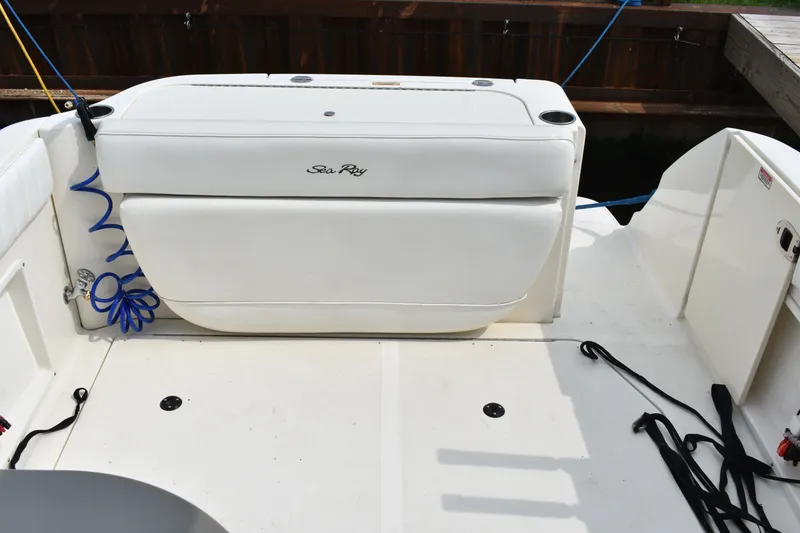 Slide: The Image of 2007 Sea Ray 270 Amberjack boat deck with white seating and storage compartments. - 12
