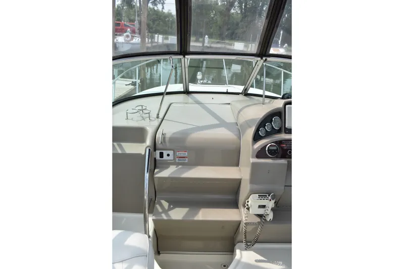 Slide: The Image of 2007 Sea Ray 270 Amberjack helm with gauges and controls, docked in a marina. - 14