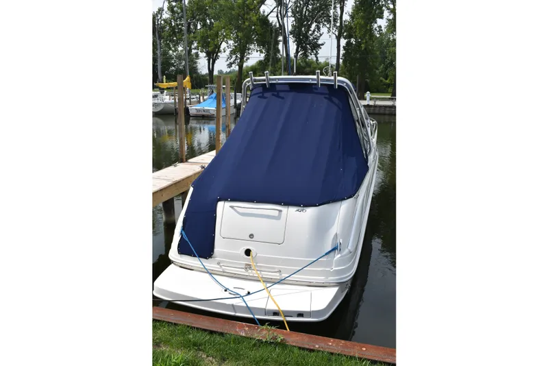 Slide: The Image of 2007 Sea Ray 270 Amberjack boat docked with blue cover in a marina. - 1