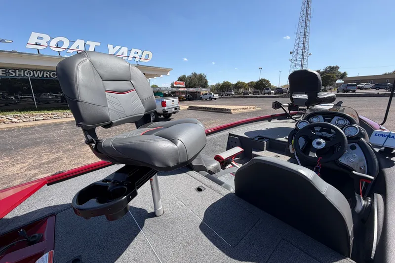 Slide: The Image of 2023 Bass Tracker Pro 17 boat interior with steering console and seating at a boat yard. - 34