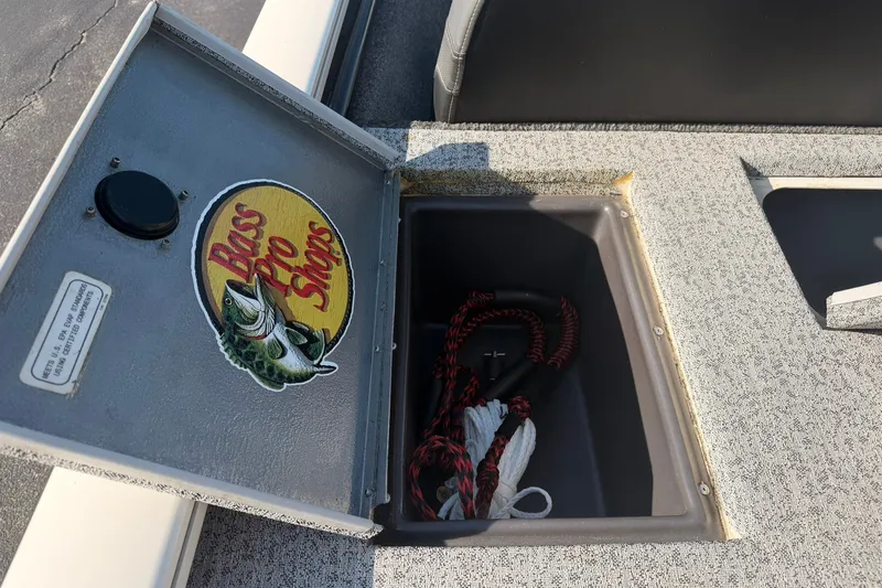 Slide: The Image of Open storage compartment on 2023 Tracker Pro Team 190 TX boat with Bass Pro Shops logo. - 48