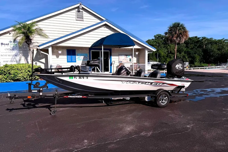 The Image of A 2023 Tracker Pro Team 190 TX Tournament Edition boat on a trailer in front of a building. - 33