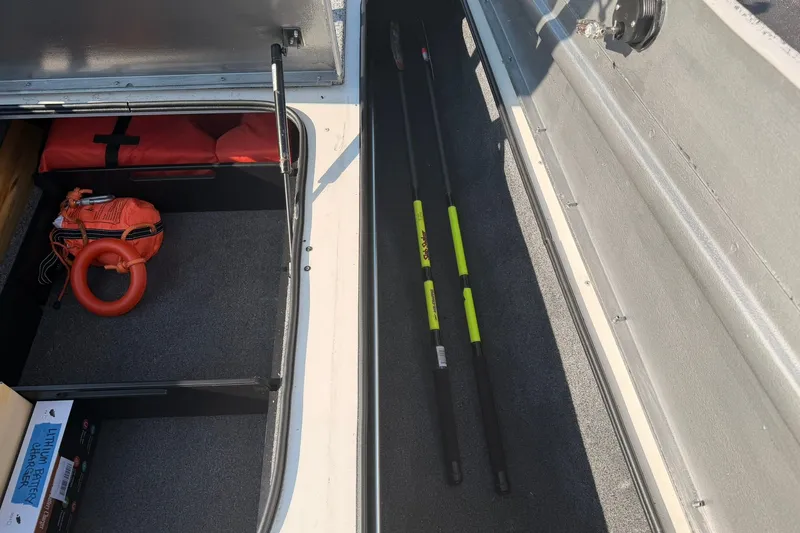 Slide: The Image of Storage compartments in a 2023 Tracker Pro Team 190 TX Tournament Edition boat, featuring safety gear and equipment. - 55