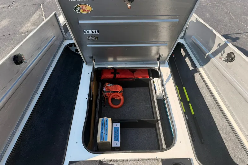 Slide: The Image of 2023 Tracker Pro Team 190 TX Tournament Edition boat storage compartment with safety gear and equipment. - 54