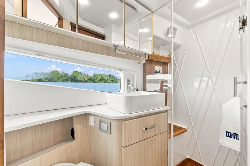 Slide: The Image of Luxurious bathroom interior of 2025 Regal 42 Grande Coupe yacht with scenic window view. - 30