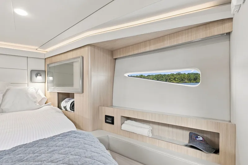 Slide: The Image of Luxurious interior of 2025 Regal 42 Grande Coupe yacht cabin with scenic window view. - 23