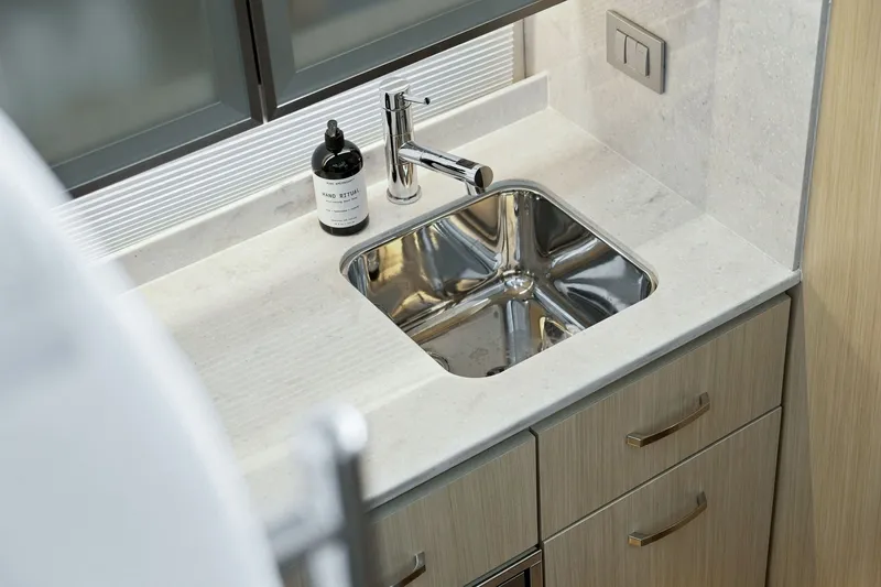 Slide: The Image of Luxurious sink area in 2025 Regal 42 Grande Coupe yacht, featuring modern fixtures and cabinetry. - 20