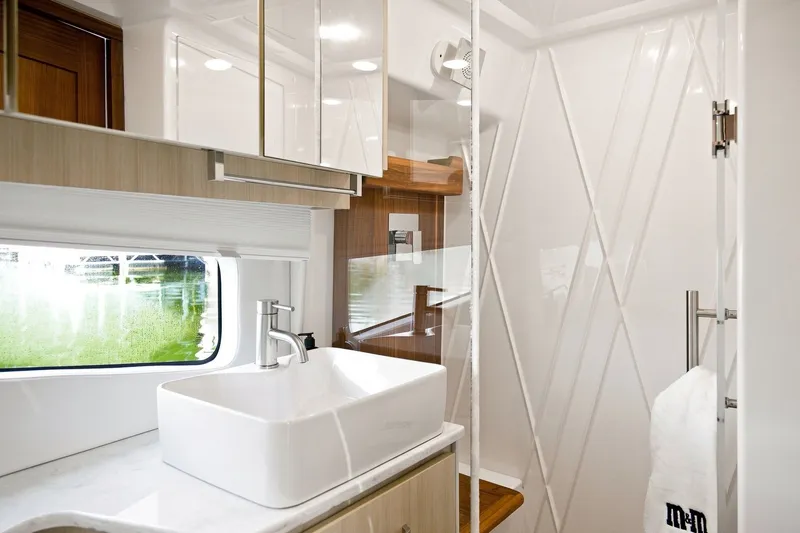 Slide: The Image of Luxurious bathroom interior of 2025 Regal 42 Grande Coupe yacht, featuring modern sink and shower. - 29