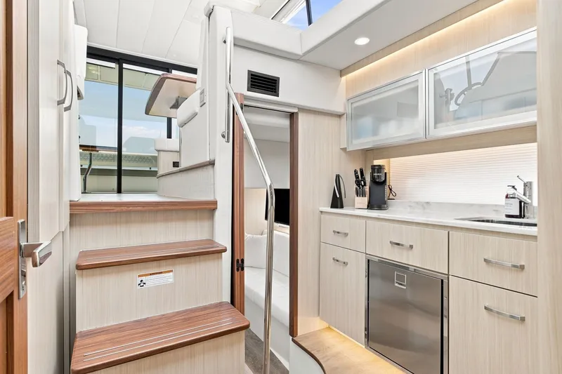 Slide: The Image of Luxurious interior of 2025 Regal 42 Grande Coupe yacht with modern kitchen and stairs. - 31