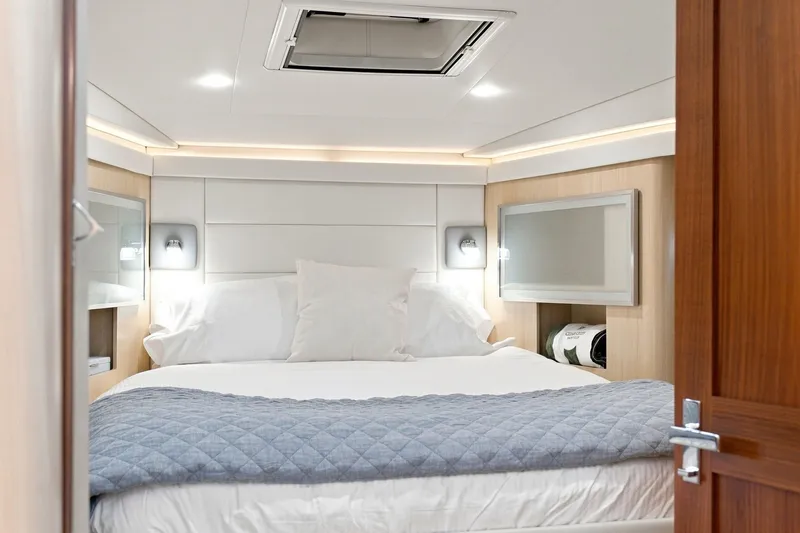 Slide: The Image of Luxurious bedroom interior of 2025 Regal 42 Grande Coupe yacht, featuring elegant bedding and modern design. - 15