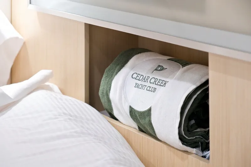 Slide: The Image of Luxury bedding with Cedar Creek Yacht Club towel on Regal 42 Grande Coupe, 2025 model. - 27
