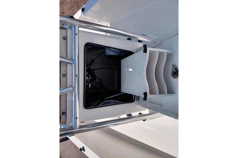 Slide: The Image of Open storage compartment on a 2020 Cobia 21 Bay boat, featuring organized shelving. - 21