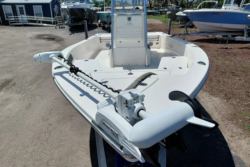 Slide: The Image of 2020 Cobia 21 Bay boat with Minn Kota trolling motor, parked outdoors. - 12