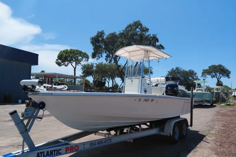 Slide: The Image of 2020 Cobia 21 Bay boat on trailer under clear blue sky. - 3