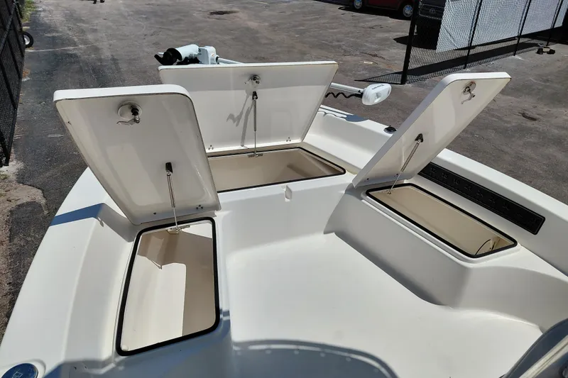 Slide: The Image of 2020 Cobia 21 Bay boat with open storage compartments on deck. - 18
