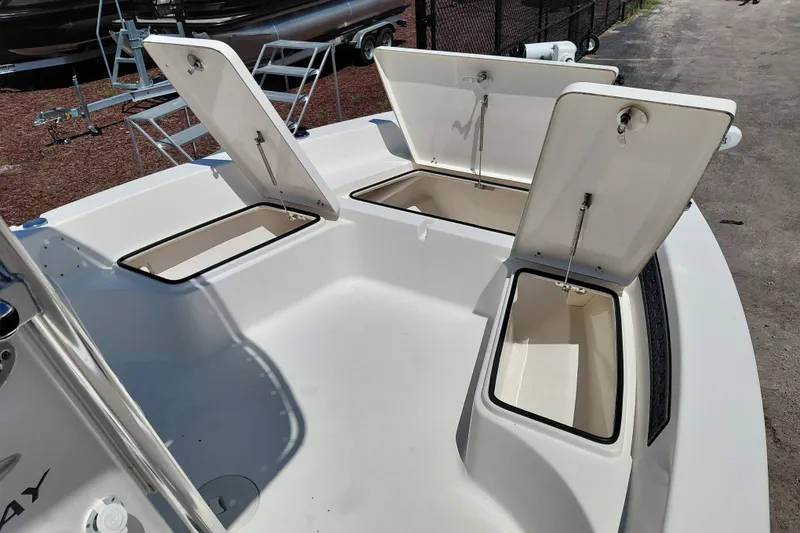 Slide: The Image of 2020 Cobia 21 Bay boat with open storage compartments on deck. - 19