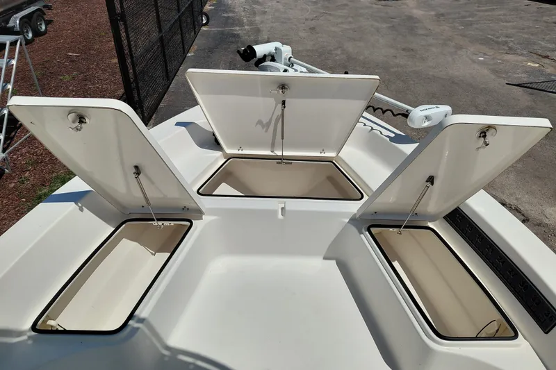 Slide: The Image of 2020 Cobia 21 Bay boat with open storage compartments on deck. - 17