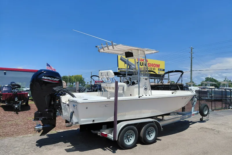 Slide: The Image of 2020 Cobia 21 Bay boat on trailer with Mercury engine, displayed outdoors. - 10