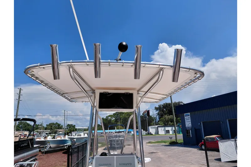 Slide: The Image of 2020 Cobia 21 Bay boat with T-top and rod holders under a clear blue sky. - 38