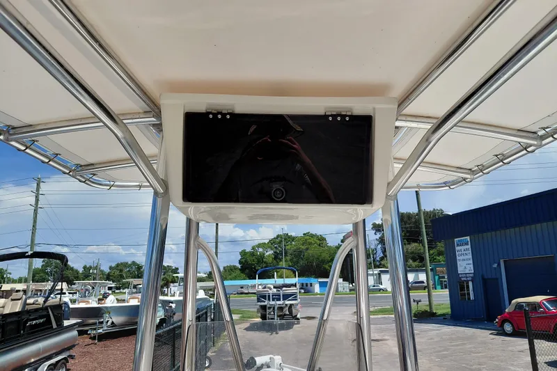 Slide: The Image of 2020 Cobia 21 Bay boat console with canopy, parked outdoors at a dealership. - 28
