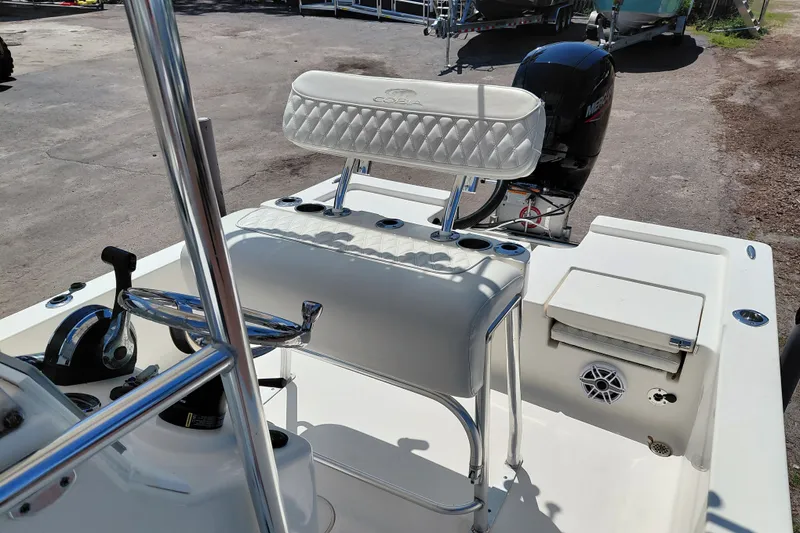 Slide: The Image of 2020 Cobia 21 Bay boat interior with seating and controls, featuring a Mercury outboard motor. - 25