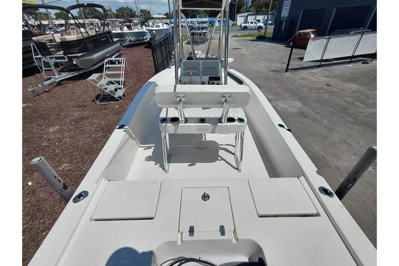 Slide: The Image of 2020 Cobia 21 Bay boat interior with seating and console, parked outdoors. - 37