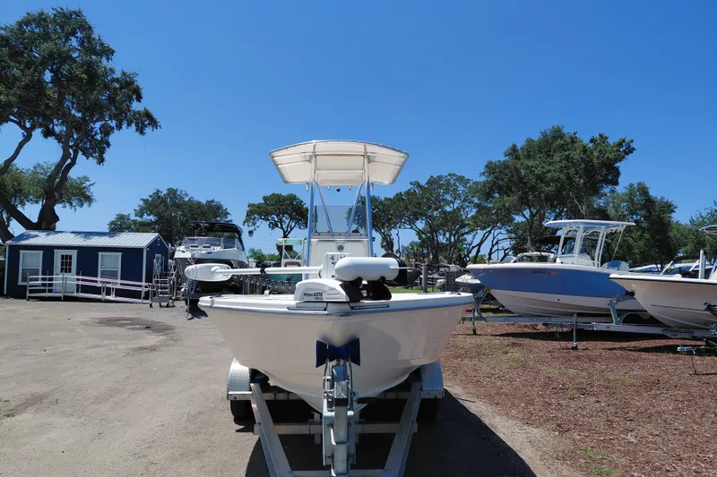 Slide: The Image of 2020 Cobia 21 Bay boat on trailer, parked outdoors under clear blue sky. - 2