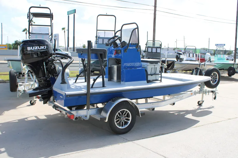 Slide: The Image of 2027 Freedom Boats Chiquita with Suzuki engine on trailer in outdoor setting. - 5
