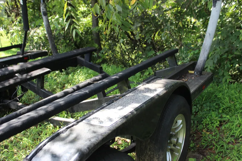 Slide: The Image of Trailer for 2015 Malibu Wakesetter 22 VLX, parked in lush greenery. - 44