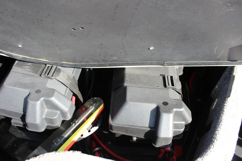 Slide: The Image of Battery compartment of a 2015 Malibu Wakesetter 22 VLX boat, featuring secured battery boxes. - 18