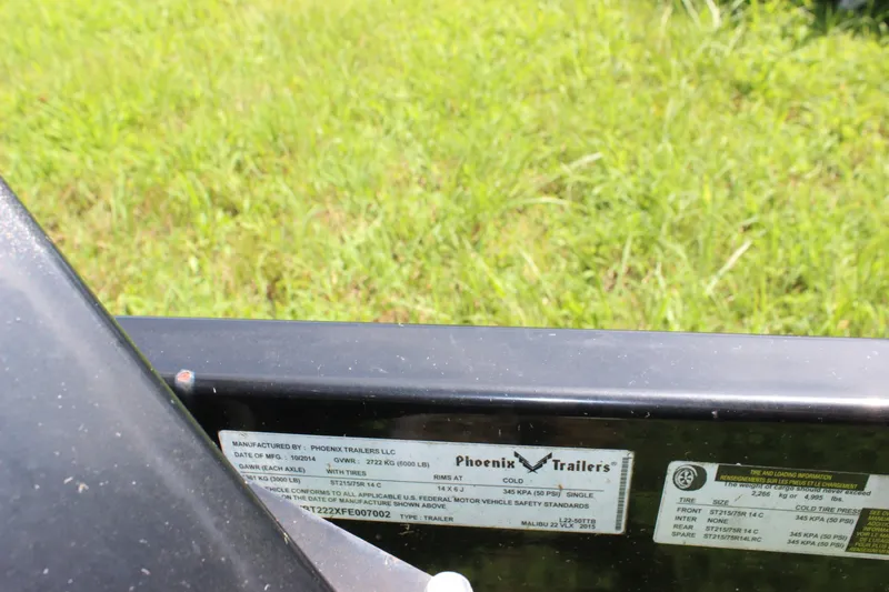Slide: The Image of 2015 Malibu Wakesetter 22 VLX trailer label by Phoenix Trailers, grassy background. - 49