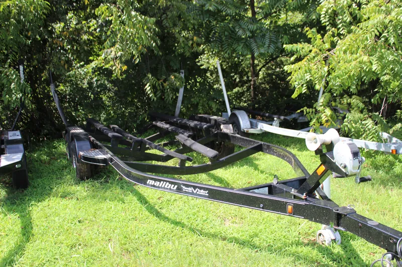 Slide: The Image of Trailer for 2015 Malibu Wakesetter 22 VLX on grass, surrounded by trees. - 40