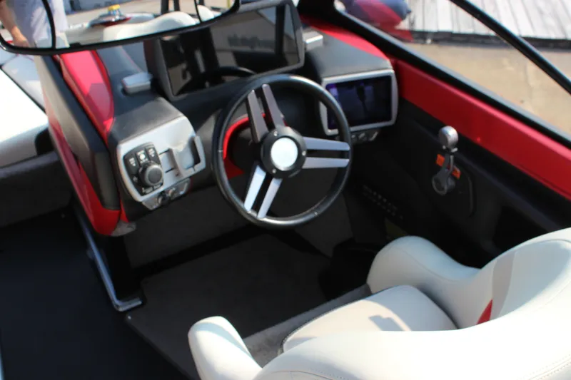 Slide: The Image of Interior of 2015 Malibu Wakesetter 22 VLX boat, featuring steering wheel and control panel. - 11