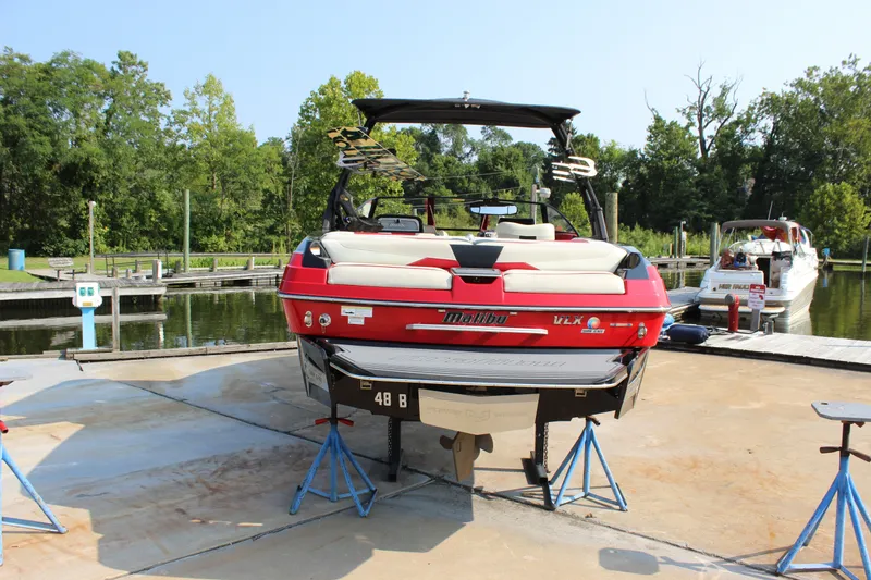 Slide: The Image of 2015 Malibu Wakesetter 22 VLX boat on stands at a marina dock. - 3