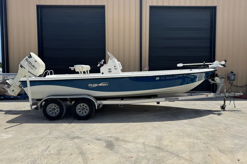 The Image of 2018 Blue Wave 2200 PureBay boat on trailer, parked outside a building. - 0