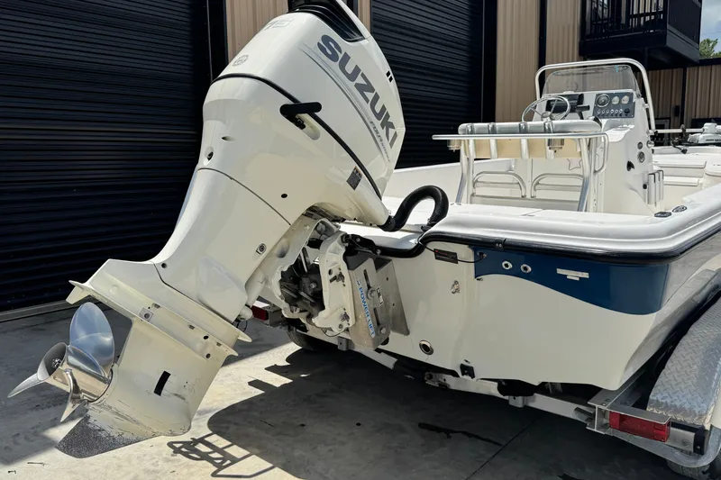 Slide: The Image of 2018 Blue Wave 2200 PureBay boat with Suzuki outboard motor in a garage setting. - 18