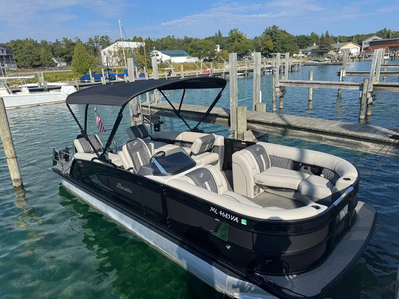 Slide: The Image of A sleek 2024 Barletta Lusso 23M pontoon boat docked in clear water. - 3