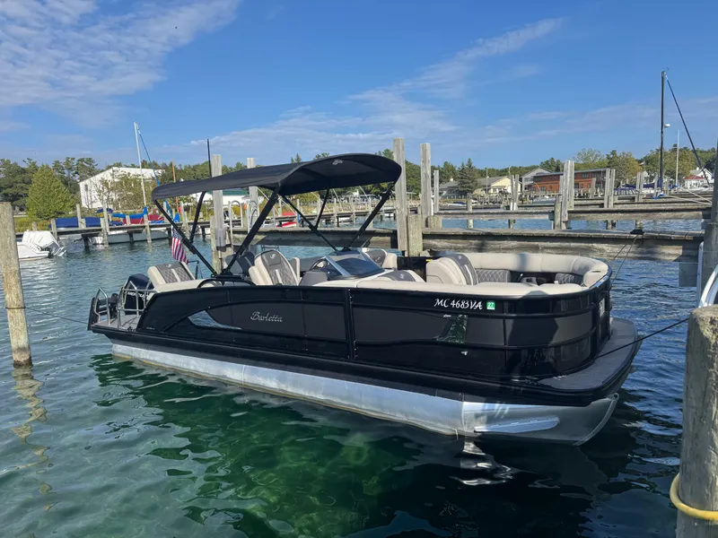 The Image of A sleek 2024 Barletta Lusso 23M pontoon boat docked in calm waters. - 2