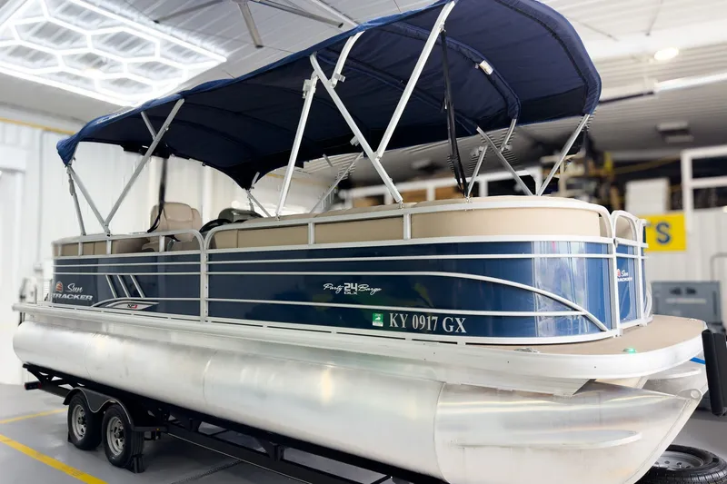 The Image of 2020 Sun Tracker Party Barge 24 XP3 pontoon boat with blue canopy in a showroom. - 0