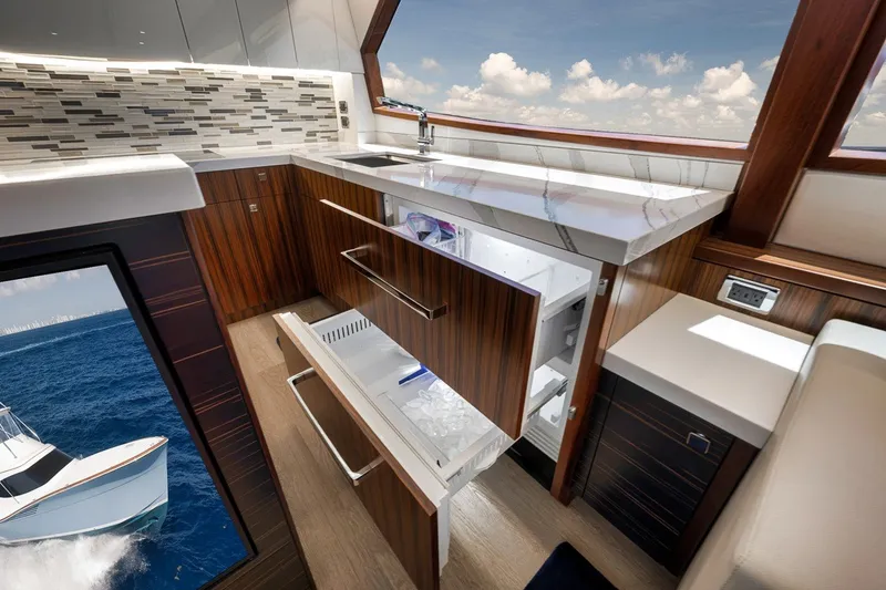 Slide: The Image of Luxurious kitchen interior of 2021 Hatteras GT65 Carolina yacht with open drawers and ocean view. - 34